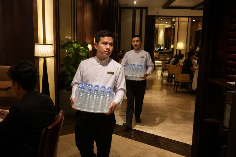 Staff carrying bottled water during dinner service